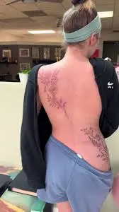 Rosie Rider modeling content on TikTok showing her signature red hair and tattoo style